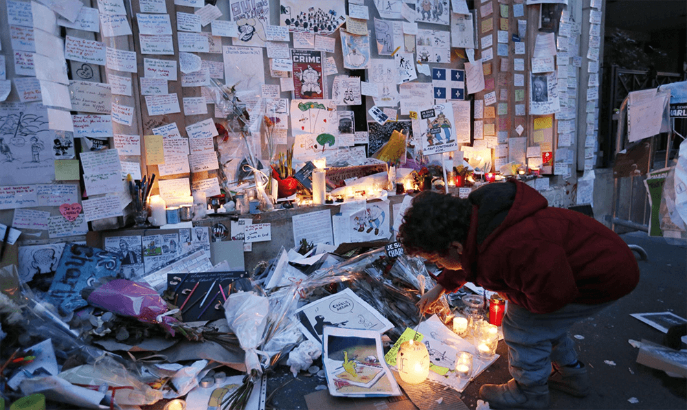 Person lighting a candle in memory of the victims of a terrorist attack